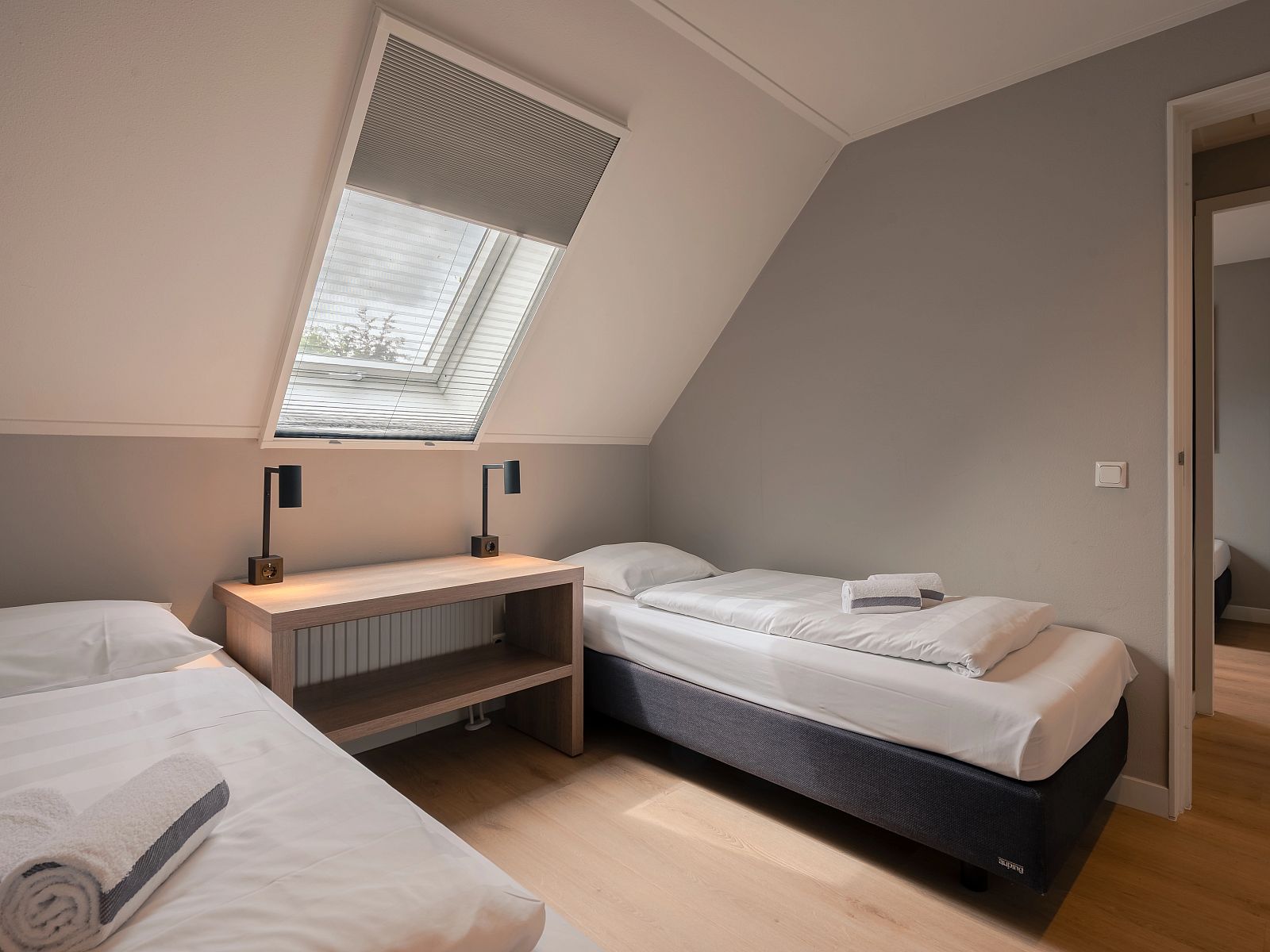 Gezellige slaapkamer met dakraam in Hof van Saksen 24-persoons boerderij, midden in de natuur van Nooitgedacht, Drenthe.