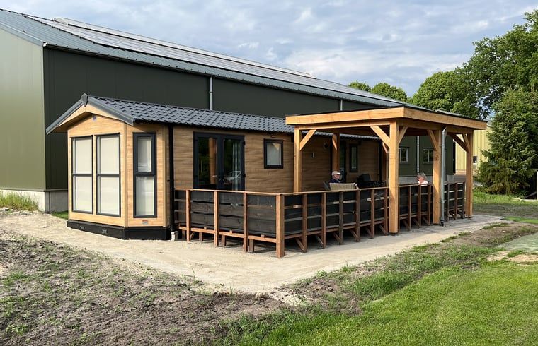 Vacation cottage in Eeserveen, Drenthe with spacious porch and green surroundings.