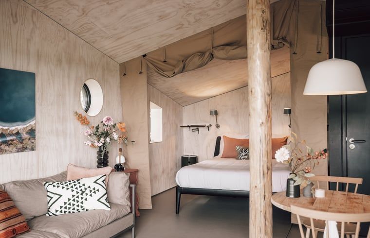 Sfeervolle zithoek en slaapkamer in Vakantiehuis in Odoorn, Midden Drenthe, met moderne decoratie.