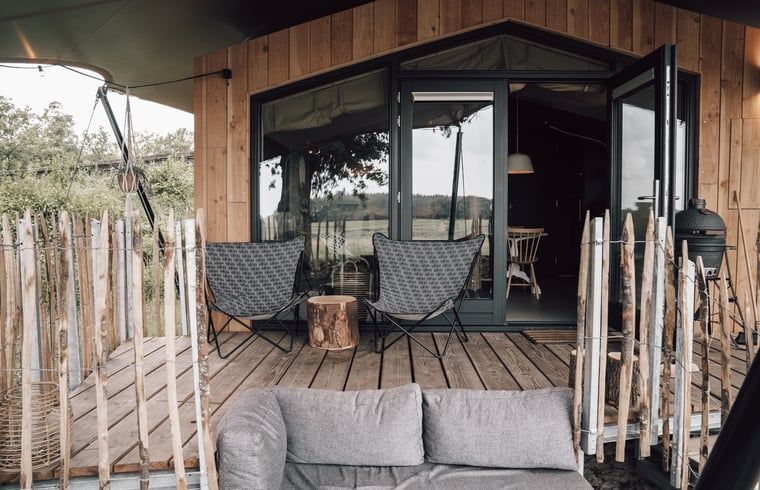 Veranda met uitzicht op de natuur bij Vakantiehuis in Odoorn, Midden Drenthe, ideaal voor ontspanning.