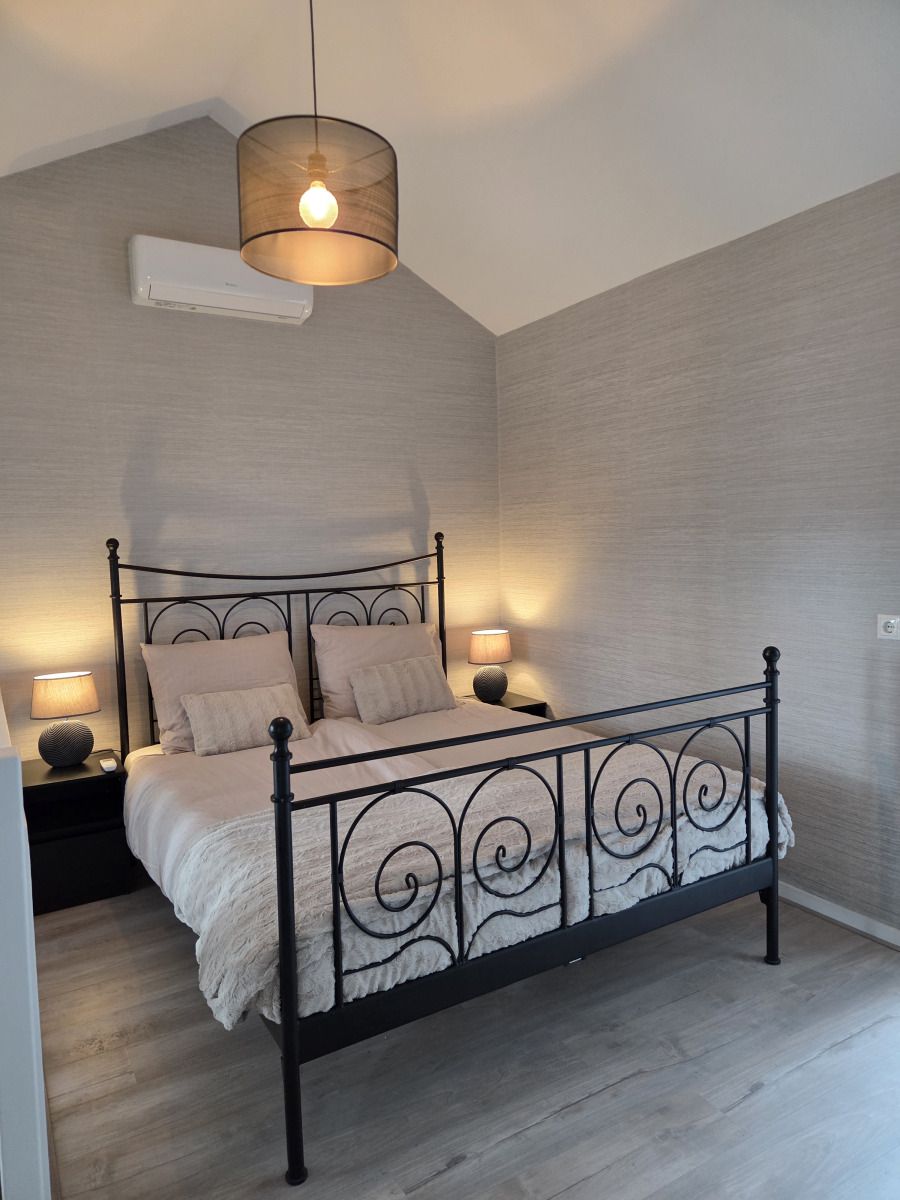 Schoenes Schlafzimmer im Ferienhaus DG2033, Odoorn, Midden Drenthe, mit einem eleganten Bett und sanfter Beleuchtung.