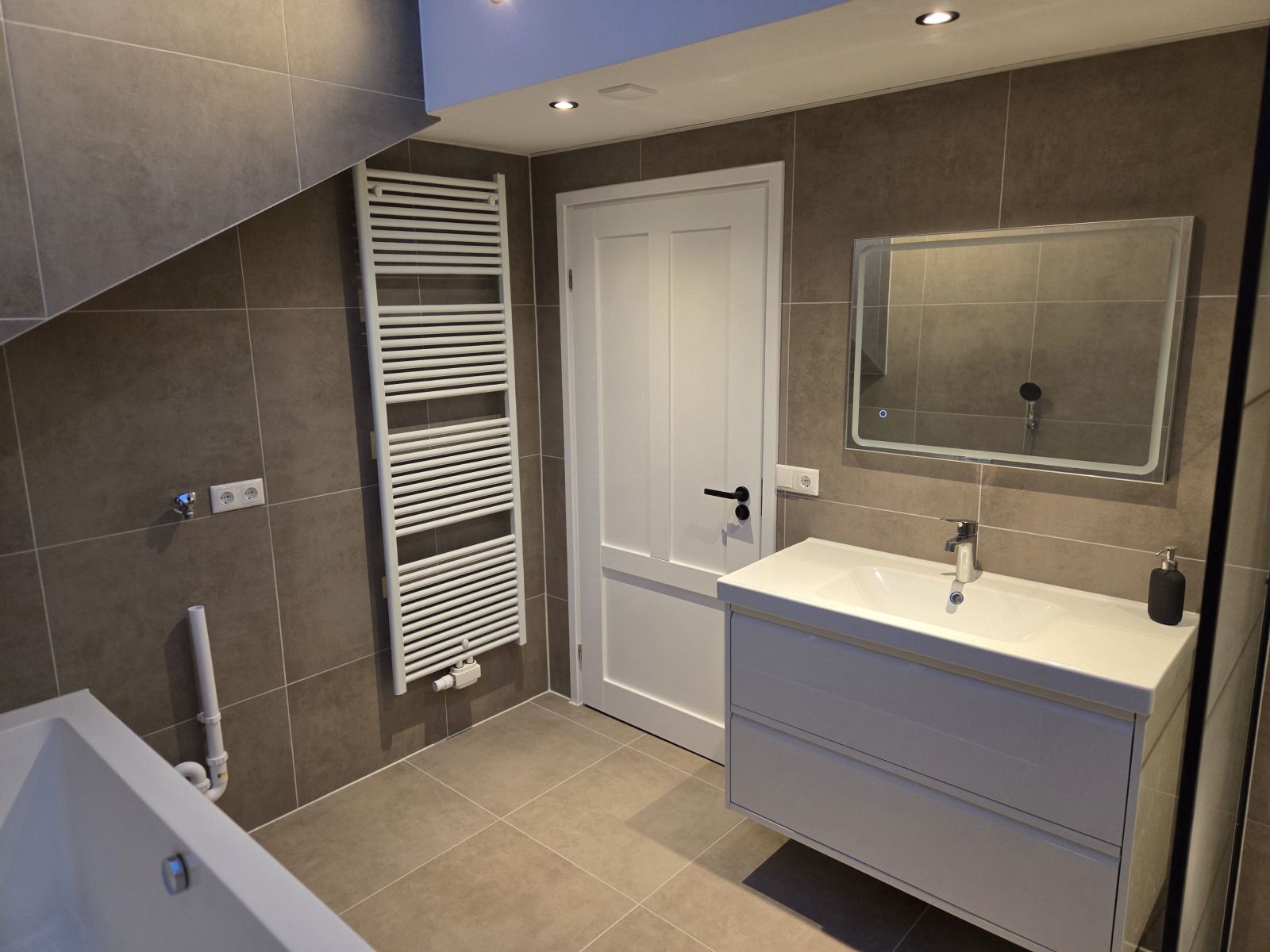 Geraeumiges Esszimmer im Ferienhaus DG2033, Odoorn, Midden Drenthe, mit grossem Tisch und bunten Blumen.