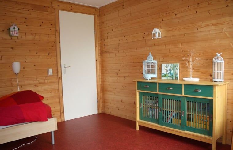 Attraktives Schlafzimmer im Ferienhaus in Nieuw Balinge, Zentral-Drenthe, mit Holzinterieur.