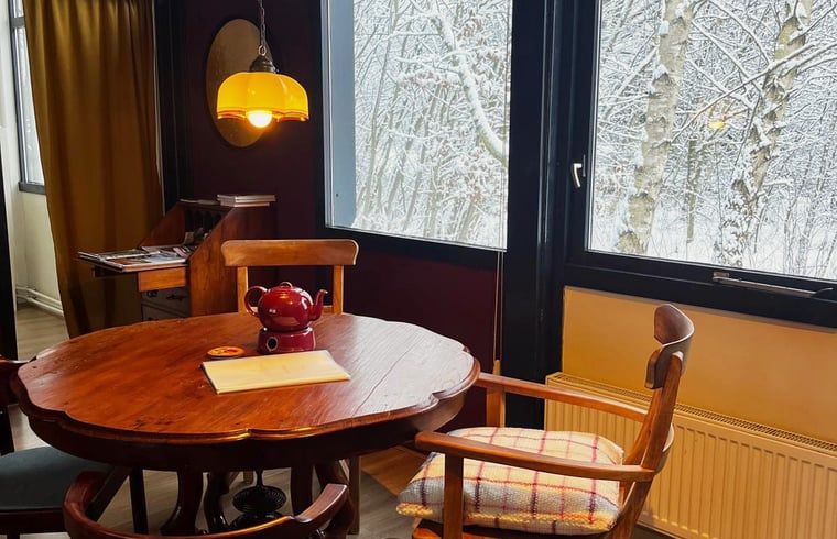 Gemuetlicher Innenbereich des Huisje in Nieuw Balinge, Ferienhaus in Zentral-Drenthe, mit stimmungsvollem Essbereich und warmer Beleuchtung.