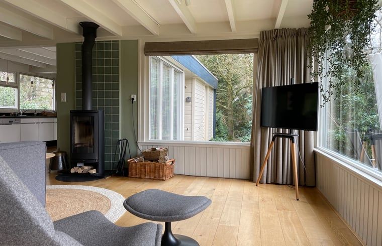 Woonkamer met houtkachel in Huisje in Een, vakantiehuis in Drenthe.