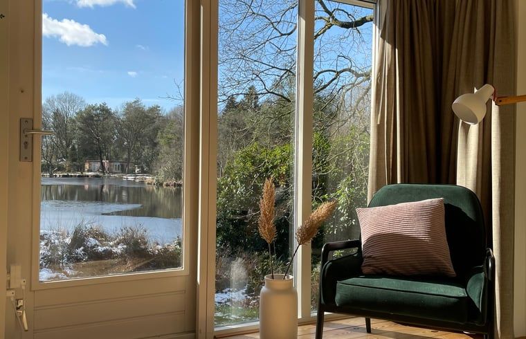 Uitzicht op het meer vanuit de woonkamer van Huisje in Een, Drenthe.