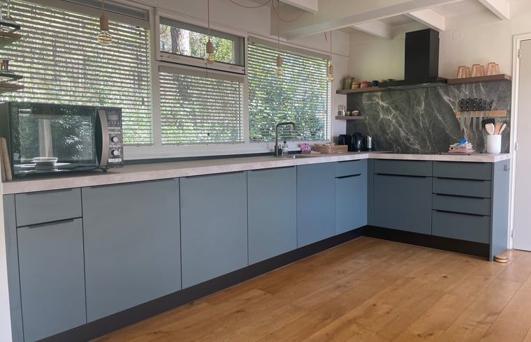 Moderne keuken met houten vloer in Huisje in Een, Noord Drenthe.