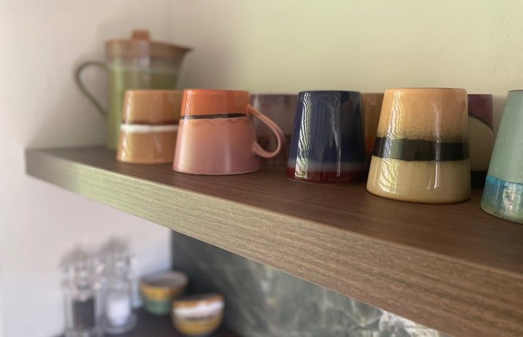 Kleurrijke mokken in de keuken van Huisje in Een, vakantieverblijf in Drenthe.