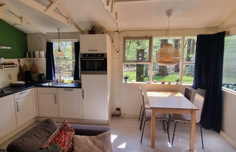 Gemuetlicher Innenbereich des Huisje in Norg, Ferienhaus in Nord-Drenthe, mit Kueche und Essbereich mit Blick auf die gruene Natur.