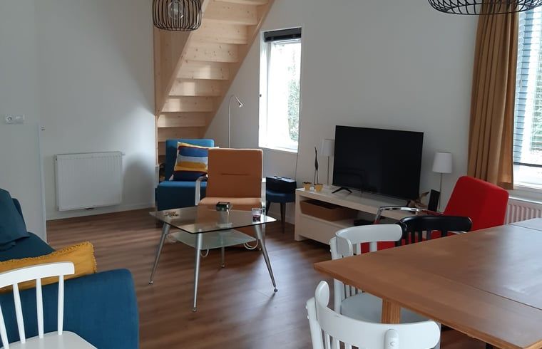 Gemuetliches Wohnzimmer des Ferienhauses in Norg, Nord-Drenthe, mit moderner Einrichtung und bequemer Sitzecke.