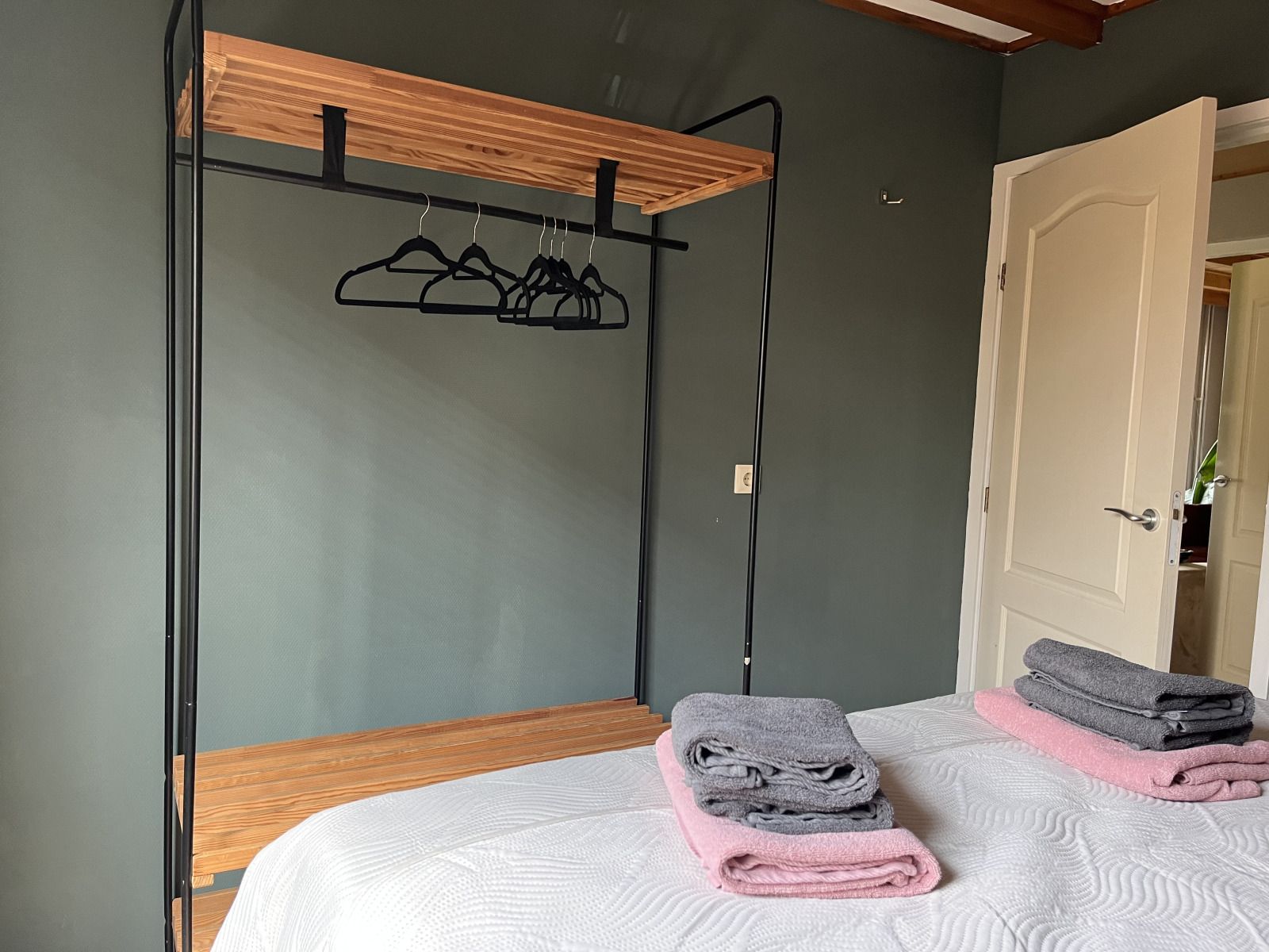 Slaapkamer in DG1879, Borger, Noord Drenthe met open kledingrek en opgemaakte bedden.