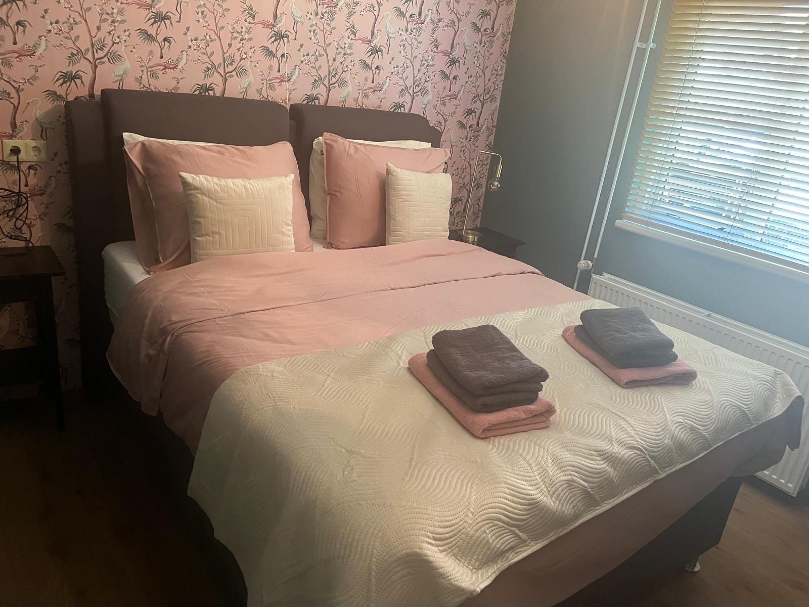 Knusse slaapkamer in DG1879, Borger, Noord Drenthe met roze accenten en comfortabele bedden.