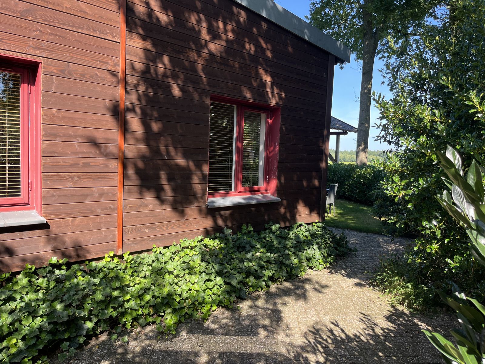 Buitenkant van vakantiehuis DG1879 in Borger, Noord Drenthe met houten gevel en groene tuin.