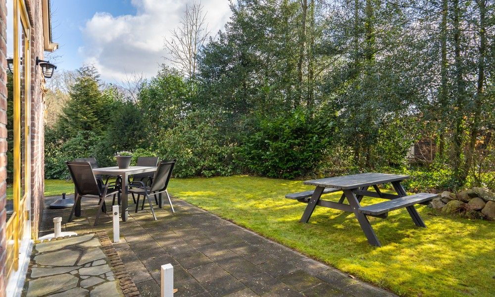 Sonnige Terrasse und Garten im Ferienhaus Vogelzang in Borger, Drenthe, ideal fuer Aktivitaeten im Freien und Entspannung.