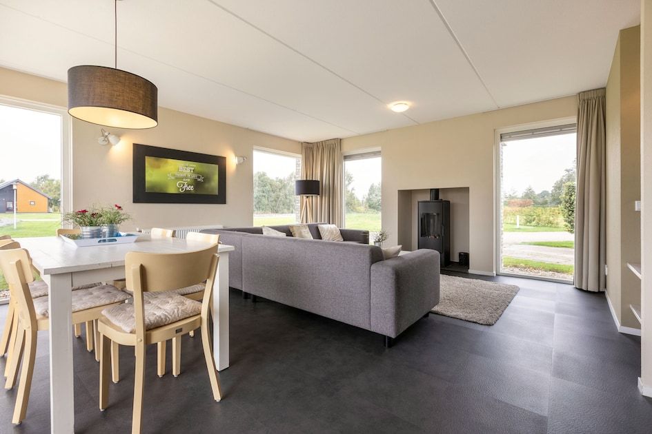 Cozy indoor area of bungalow Drentsche Aa 6 in Tynaarlo, North Drenthe, overlooking the green surroundings and modern dining room.