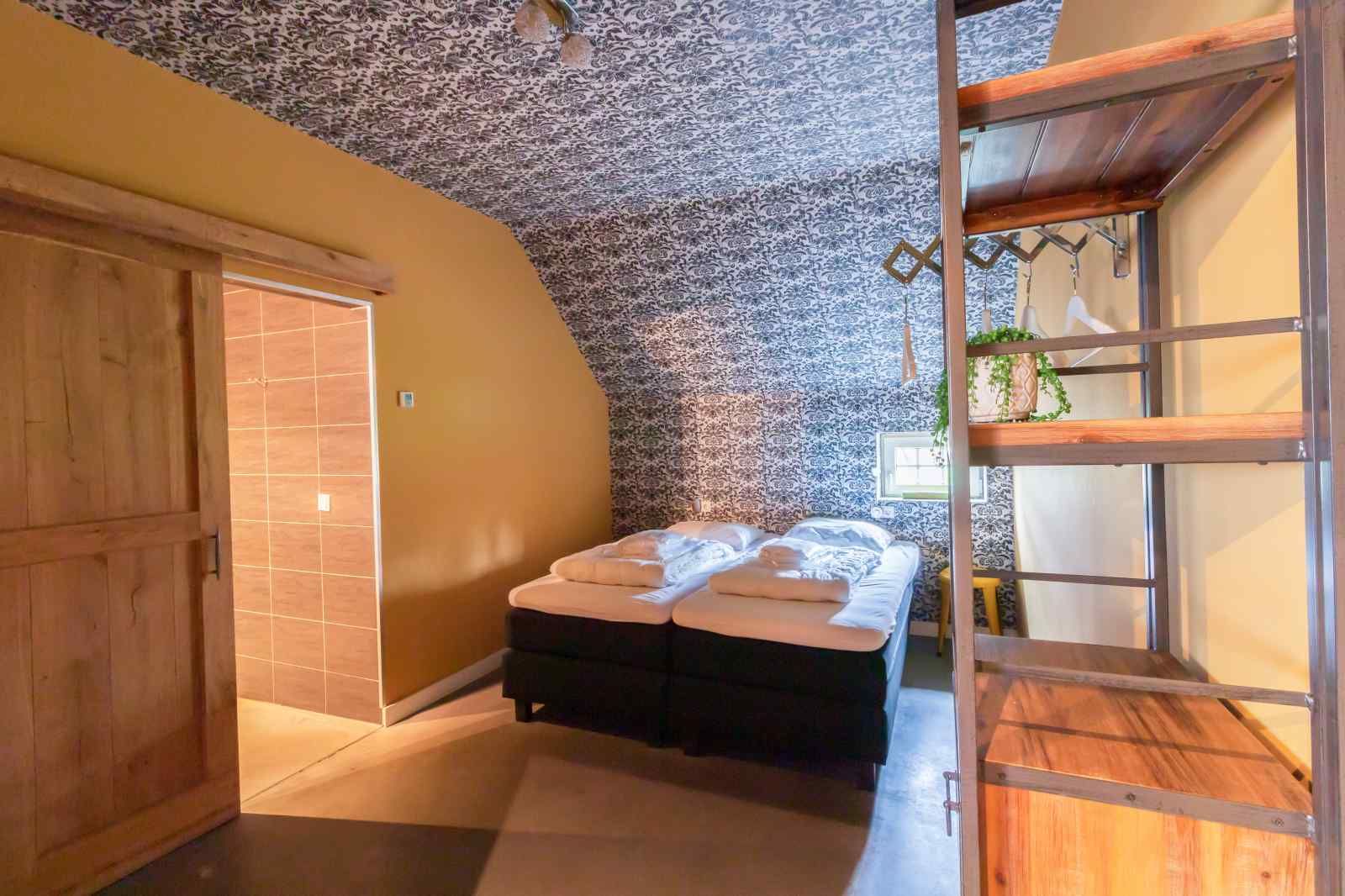 Stilvolles Schlafzimmer im Ferienhaus DG705 Ellertshaar Drenthe mit Blumentapete.