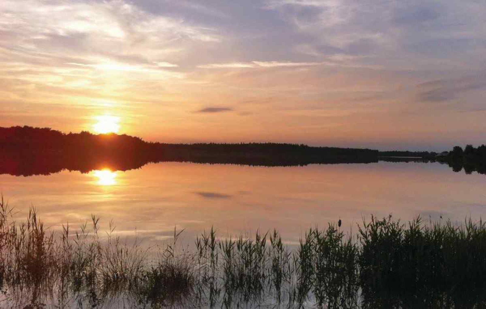 Essecke im DG705 Ferienhaus Ellertshaar Drenthe mit grossem Tisch und stimmungsvoller Beleuchtung.