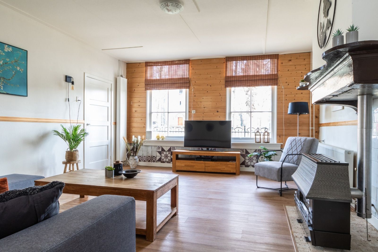 Geraeumiges Wohnzimmer im Ferienhaus DG984, Vries, Drenthe, mit Fernseher und bequemen Stuehlen.