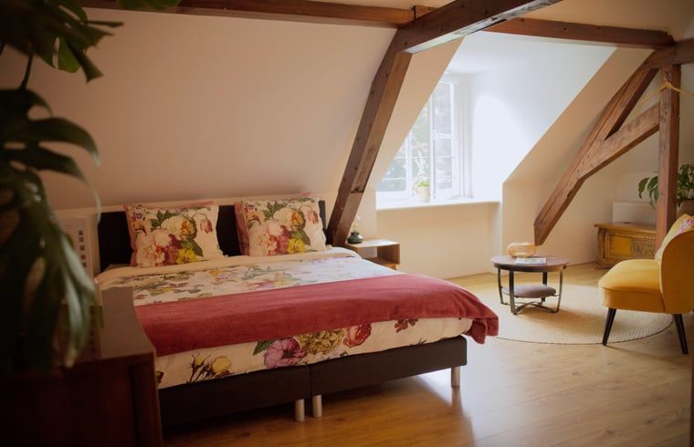 Ruime slaapkamer onder het dak van Vakantiehuis in Veenhuizen, charmant verblijf in Drenthe.