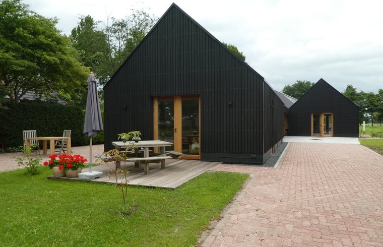 Huisje in Bunne, een modern vakantiehuis in Noord Drenthe met een uitnodigend terras en groene omgeving voor ultiem ontspannen.