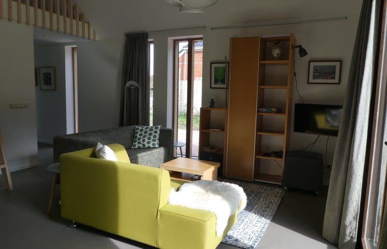 Gezellige woonkamer van Huisje in Bunne, vakantiehuis in Noord Drenthe, met moderne inrichting en veel natuurlijk licht.