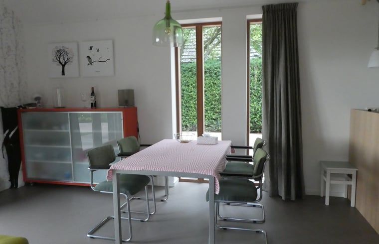 Gezellige eetruimte in Huisje in Bunne, een vakantiehuis in Noord Drenthe, met modern interieur en uitzicht op de groene tuin.