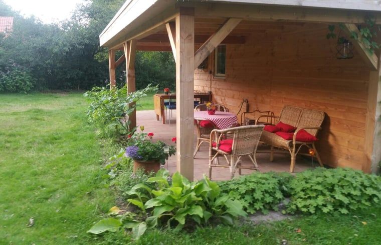 Geniet van de rust op de veranda van Vakantiehuis in Drouwen, omgeven door de natuur in Noord Drenthe, Drenthe.