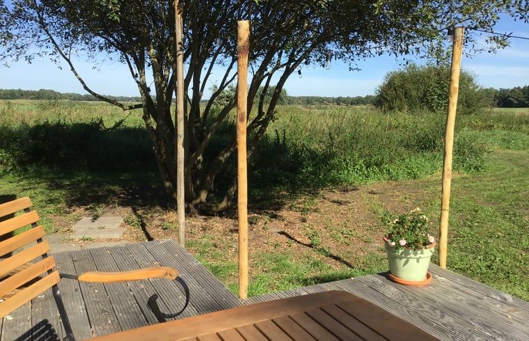 Zonnig terras met groene omgeving in Vakantiehuis in Ekehaar, Noord Drenthe, Drenthe.