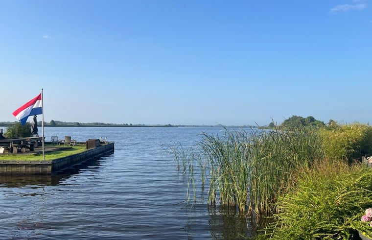 Atemberaubende Aussicht auf den See vom Cottage in Matsloot, einem Ferienhaus in Nord-Drenthe, umgeben von einer ruhigen Landschaft.