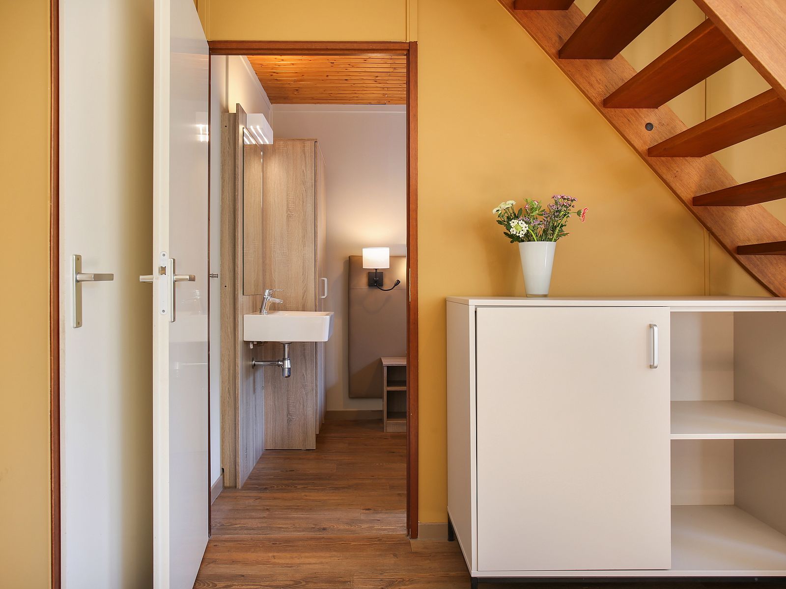 Bedside table with reading lamp in Aelderholt 6-person bungalow 6CE, Aalden, Drenthe.