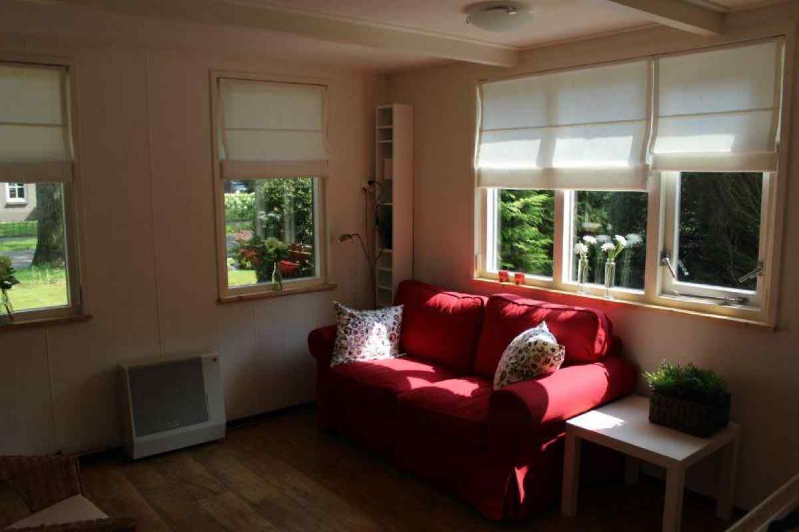 Geniessen Sie den ruhigen Innenhof des Ferienhauses DG280 in Exloo, Suedost-Drenthe, umgeben von Gruen und Blumen.