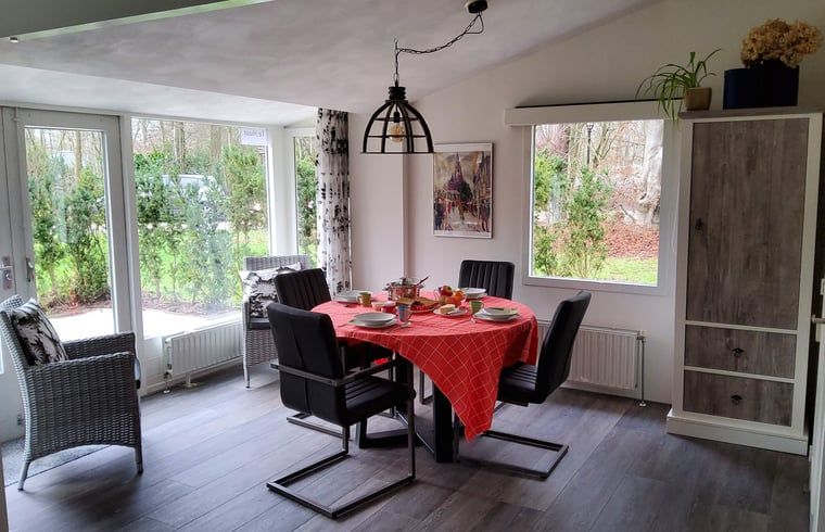 Essecke im Cottage in Exloo, Ferienunterkunft in Suedost-Drenthe mit Blick auf den Garten.