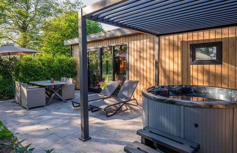 Relax on the terrace of Holiday Home in Dalerveen, Southeast Drenthe with comfortable lounge chairs and a luxurious Jacuzzi.