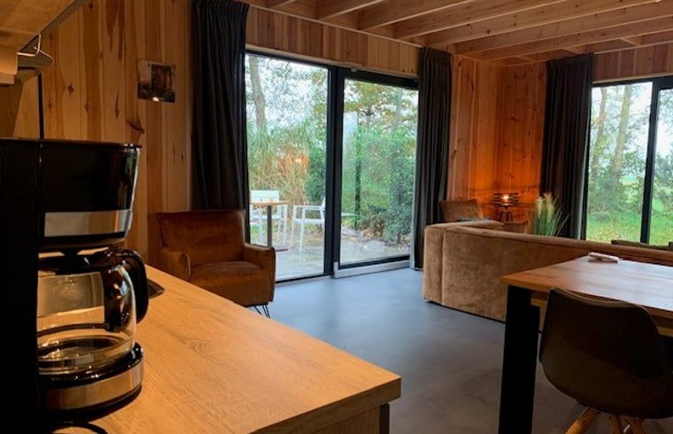 Modern interior space of Holiday Home in Dalerveen, Southeast Drenthe with coffee maker and garden view.