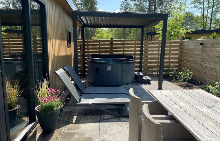 Spacious terrace at Holiday home in Dalerveen, Southeast Drenthe with jacuzzi and deck chairs.