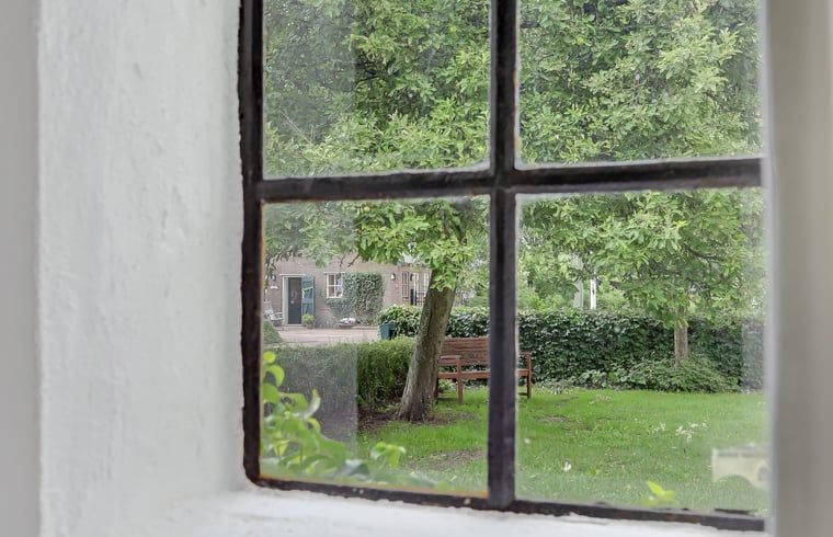 Uitzicht vanuit Vakantiehuisje in Dalerveen, Zuidoost Drenthe, met groene tuin en rustieke charme.