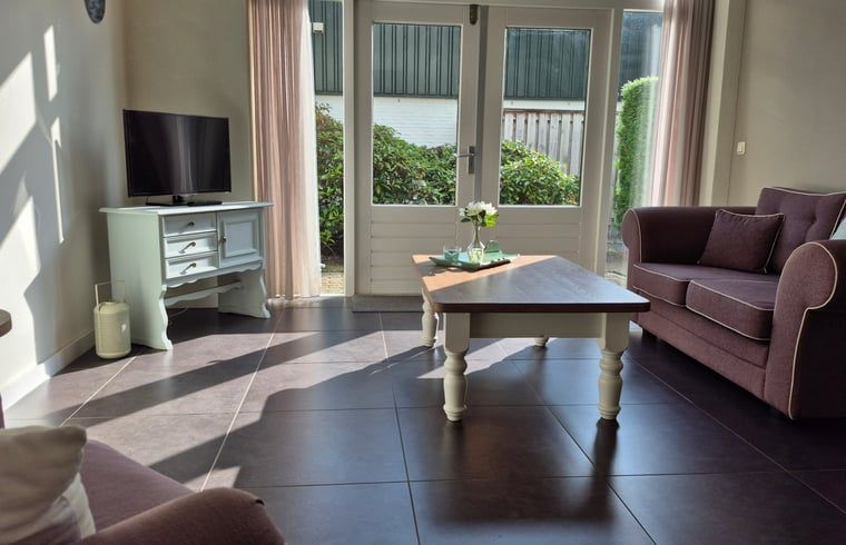 Cozy living room in Holiday Home in Dalerveen, Southeast Drenthe, with comfortable sofas and views of the garden.