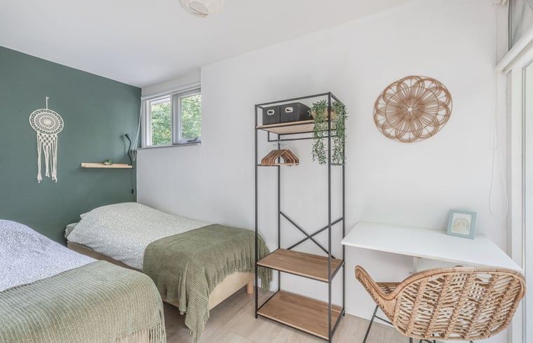 Buitenzijde van Vakantiehuis in Schoonoord, Drenthe met terras, hangmat en groene omgeving.