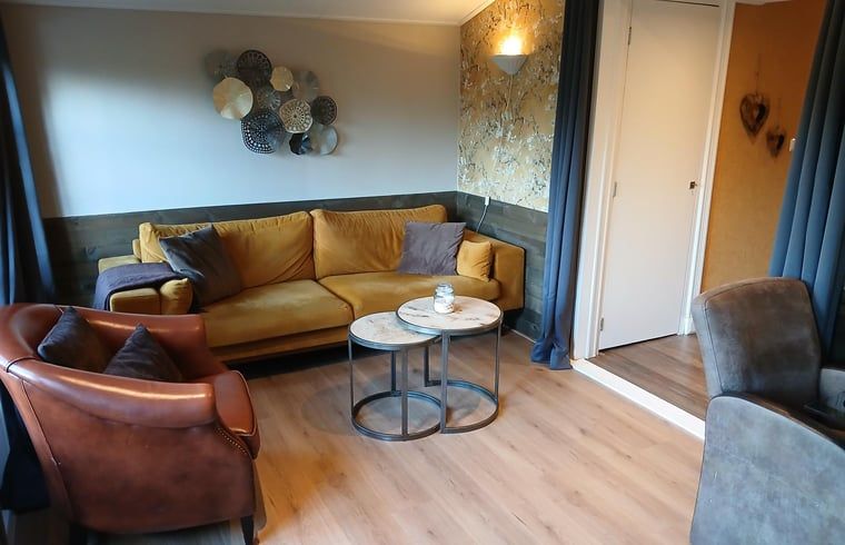 Gezellige woonkamer in Vakantiehuisje in Stieltjeskanaal, Zuidoost Drenthe. Comfortabele zitruimte perfect voor ontspanning in een landelijke omgeving.