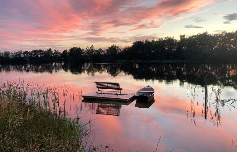 Geniet van de serene zonsondergang bij Vakantiehuisje in Odoornerveen, gelegen aan een idyllisch meer in Zuidoost Drenthe.
