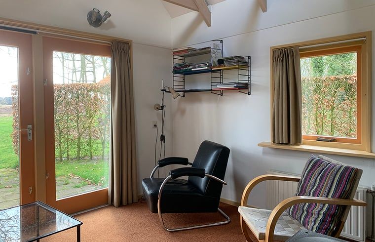 Lichte woonkamer in Huisje in Zuidwolde, vakantiehuis in Zuidwolde met uitzicht op de tuin.