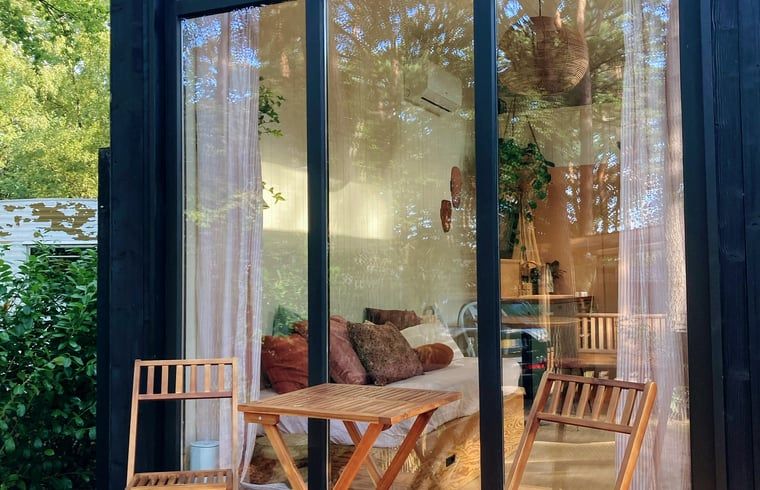 Gemuetliche Sitzecke mit Glasfassade in Cottage in Zuidwolde, Ferienhaus in Suedwest-Drenthe, umgeben von ruhiger Natur.