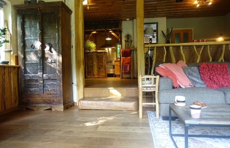 Gezellige woonkamer in Huisje in Zuidwolde, vakantiehuis in Zuidwest Drenthe, met rustieke houten meubels en warme inrichting.