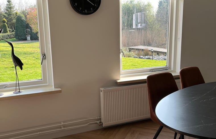 Uitzicht vanuit Huisje in Nieuweroord, vakantiehuis in Zuidwest Drenthe, met groene tuin en veel natuurlijk licht.