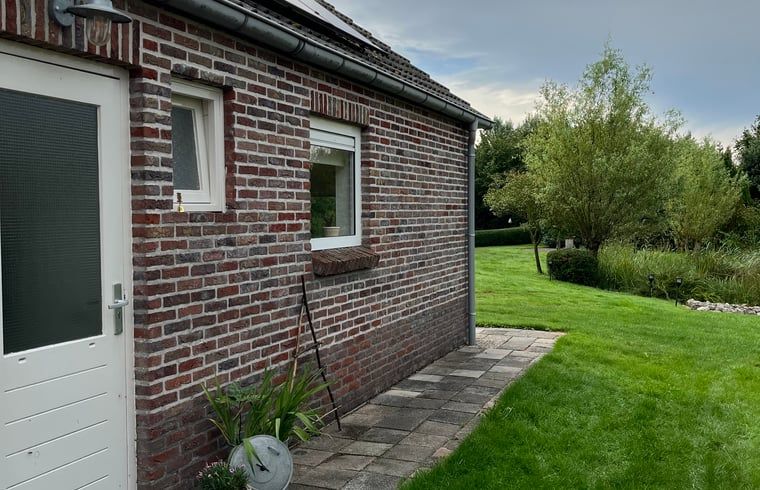Buitenzijde van Huisje in Nieuweroord, vakantiehuis in Zuidwest Drenthe, omgeven door groene grasvelden.