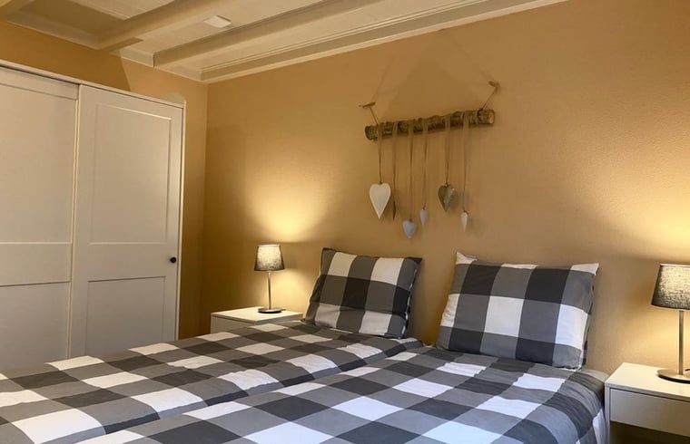 Sfeervolle slaapkamer in Vakantiehuisje in Ruinen, Zuidwest Drenthe, met tweepersoonsbed en warme inrichting.