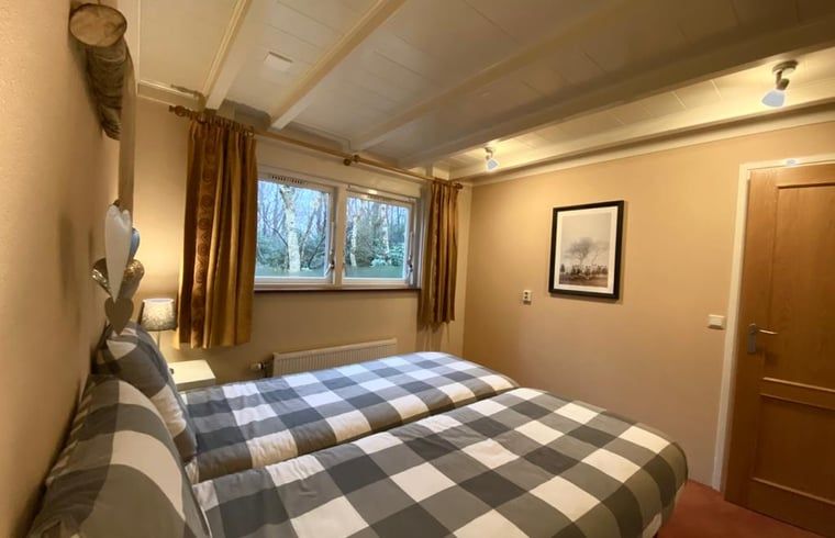 Knusse slaapkamer in Vakantiehuisje in Ruinen, Zuidwest Drenthe, met uitzicht op de omliggende natuur.