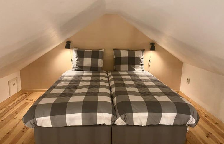 Zolderkamer met tweepersoonsbed in Vakantiehuisje in Ruinen, Zuidwest Drenthe, biedt een knusse slaapervaring.