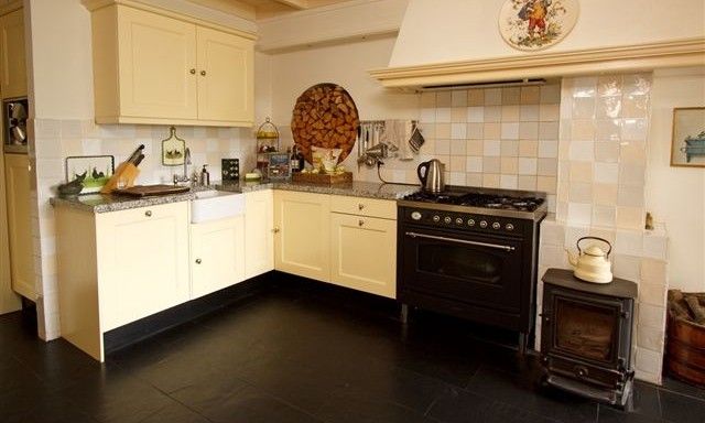 Laendliche Kuechenecke in Hoeve den Anholt, Ruinen, Drenthe, mit klassischem Ofen und stimmungsvollem Holzherd.