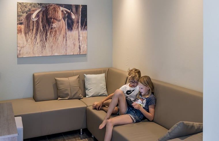Kinderen ontspannen in de woonkamer van Huisje in Wapserveen, Zuidwest Drenthe, Drenthe.